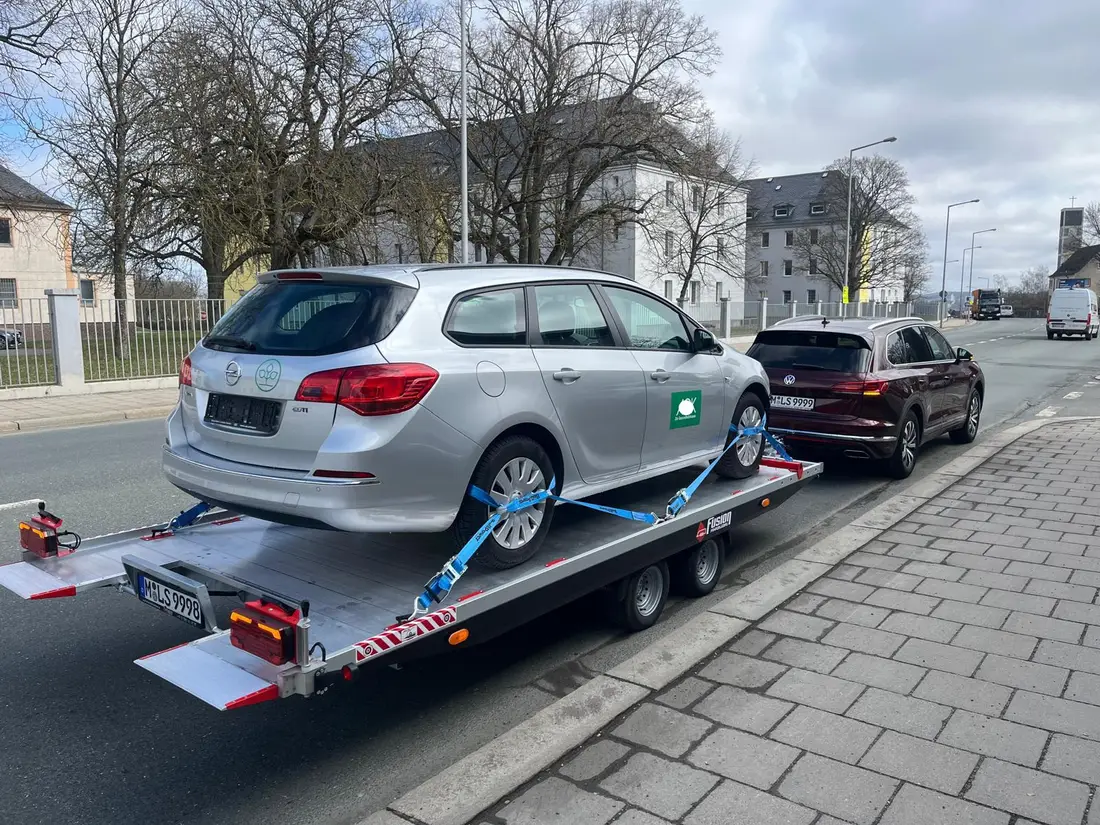 Kombi auf dem Anhänger, gesichert mit Radgurten